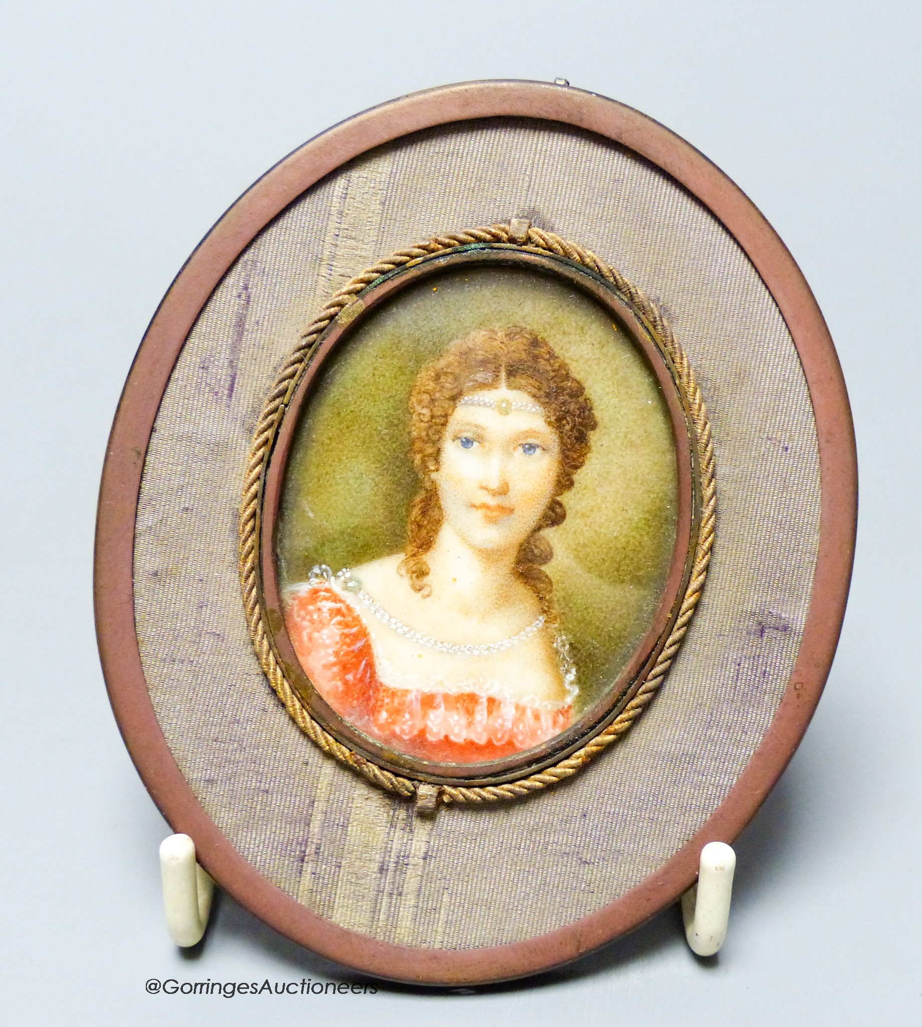 An oval framed miniature of a lady in red, height 5cm